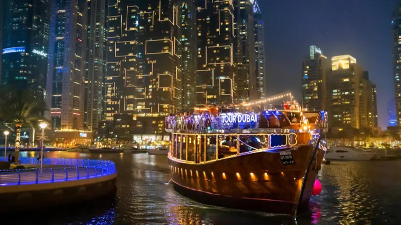 Traditional dhow cruise sailing through Dubai Marina illuminated at night