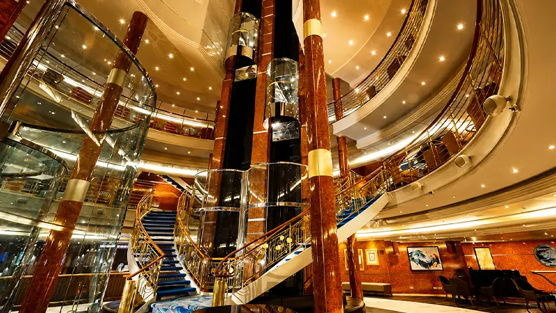 Luxurious atrium with grand staircase and elevators inside the Cordelia Cruise
