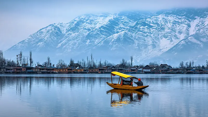 Shikara boat cruising on Dal Lake with snow-capped Himalayan peaks