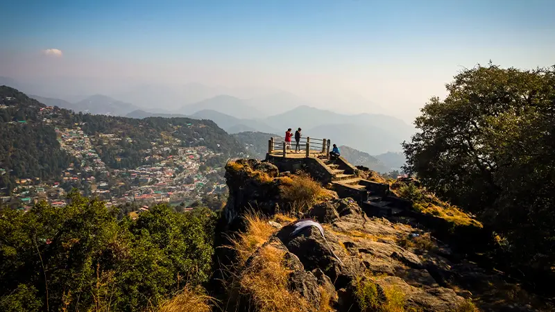 Visitors enjoying panoramic Himalayan valley views from a mountain viewpoint