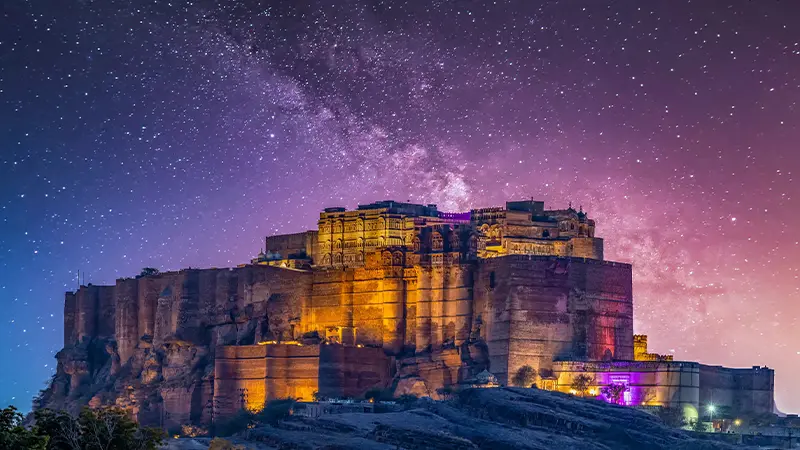 Illuminated Mehrangarh Fort under a star-filled night sky in Jodhpur Rajasthan