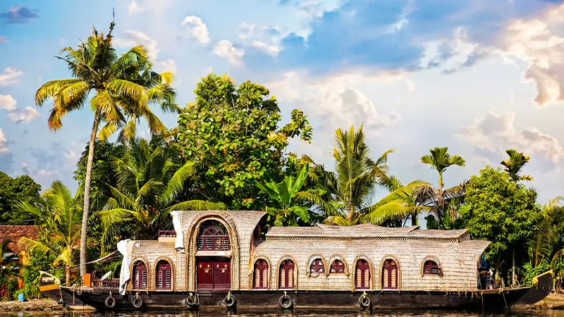 Traditional luxury houseboat cruising through peaceful backwaters
